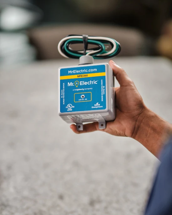 MRE Electrician holding a surge protector.